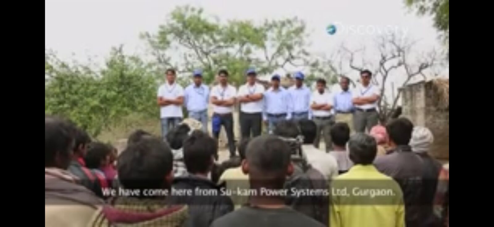 Su-Kam team in branded uniforms addressing villagers — 