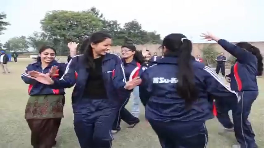 Su-Kam employees in tracksuits clapping and celebrating outdoors at a team event